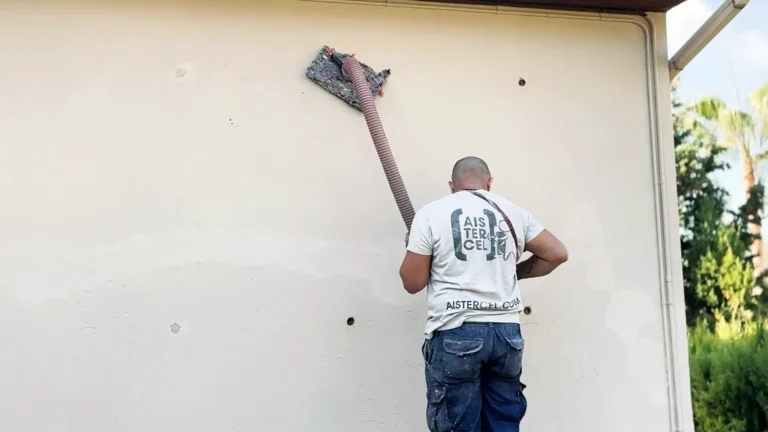 Técnico de Aistercel insuflando celulosa desde el exterior para aislar una casa en Collbató